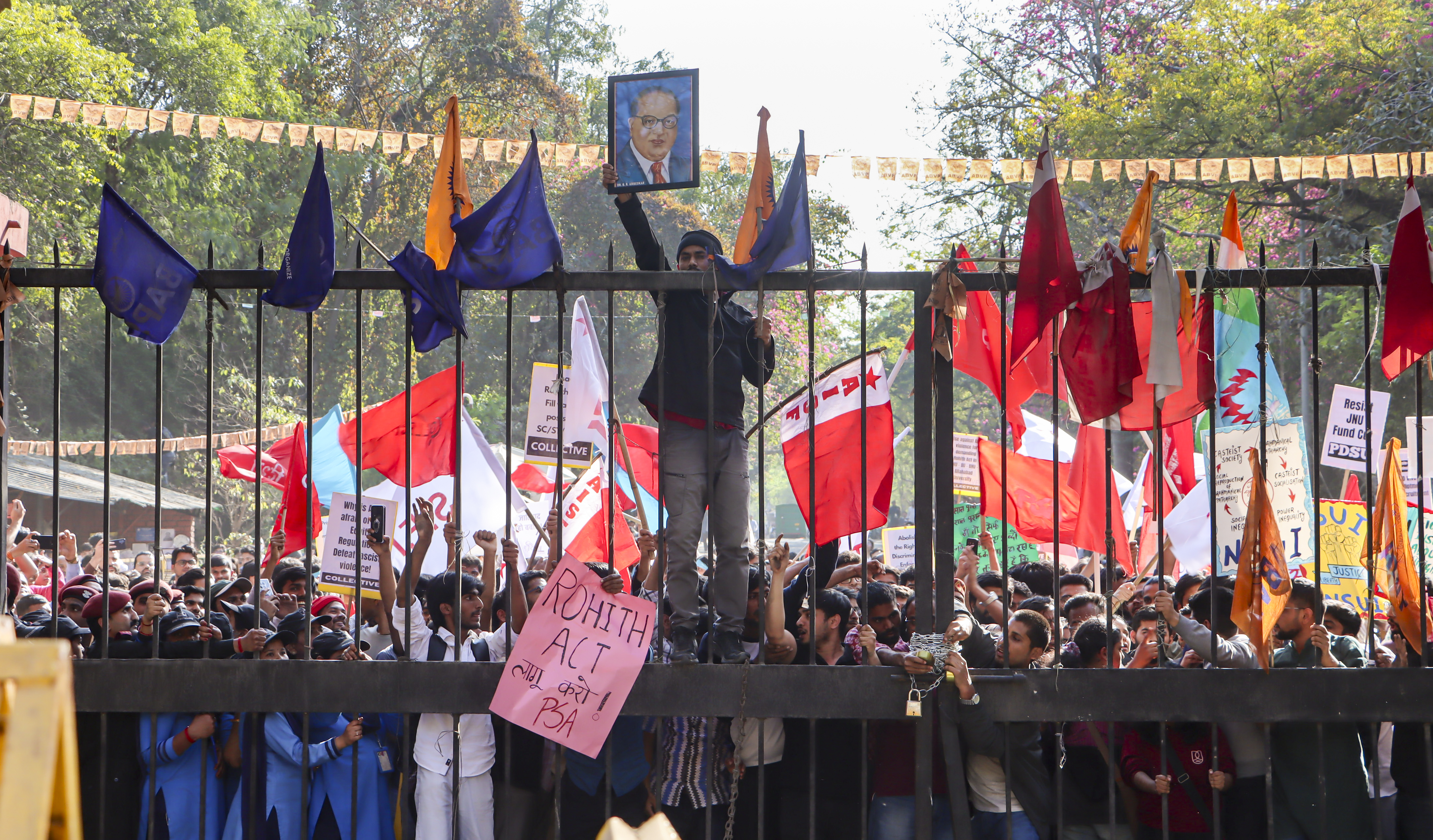 Protesting students, seen holding photos of Dr BR Ambedkar, gather at JNU main gate demanding the implementation of a law to prevent caste discrimination even as they are stopped by heavy deployment of Delhi Police on 26 February. (Photo: PTI)
