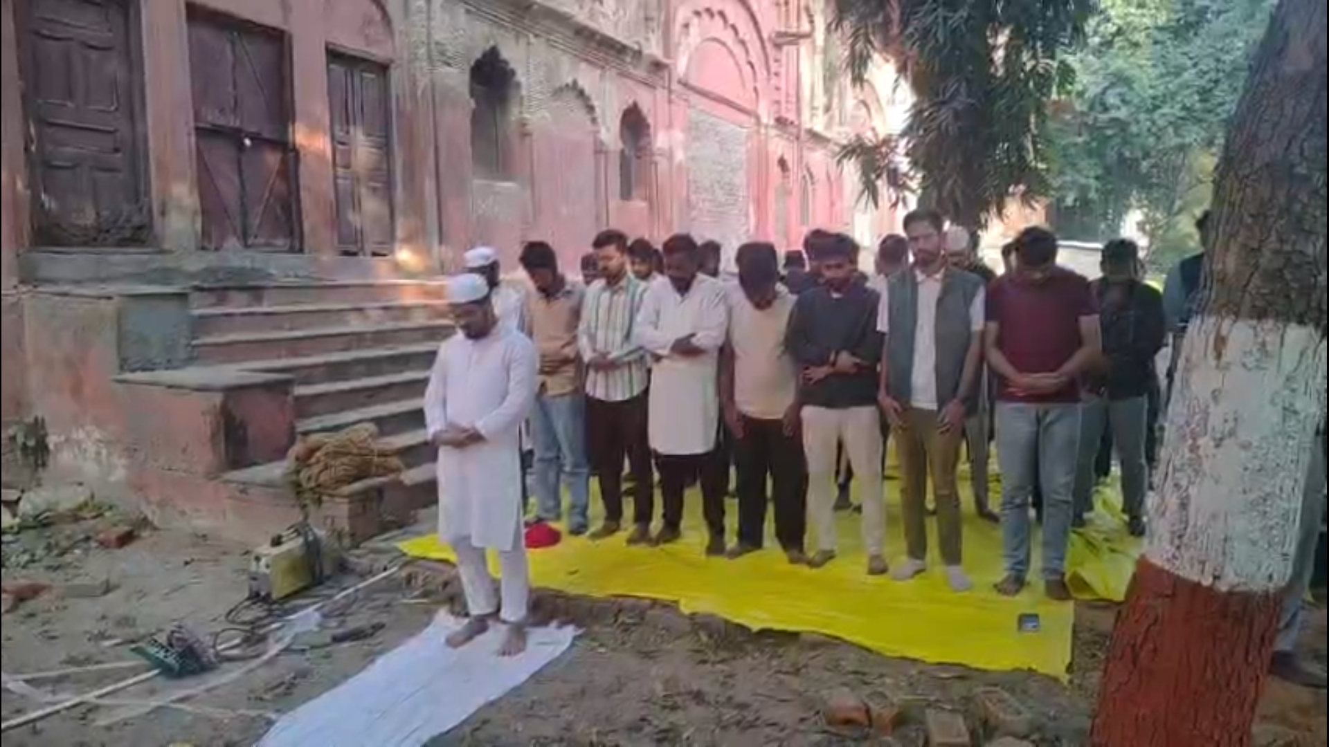 Students offering namaz outside the Lal Baradari, as a few students safeguarded them by forming a human chain on 22 February. (Photo: Accessed by The Quint)